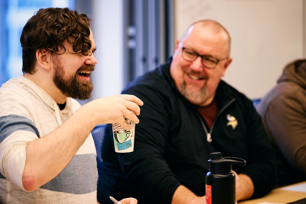 Two Made In Tandem colleagues sharing a laugh during a working meeting